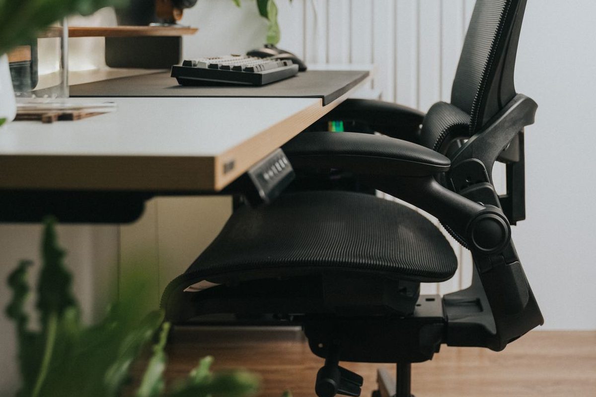 Posto de trabalho com cadeira ergonômica e mesa regulável