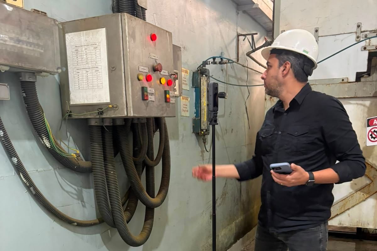 Engenheiro de segurança em vistoria, com instrumento de medição junto a painel elétrico